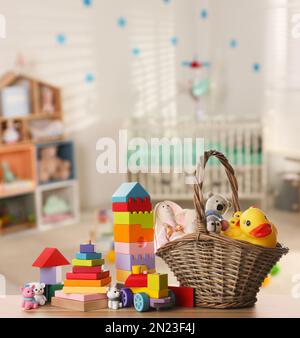 Set mit verschiedenen niedlichen Spielzeugen auf Holztisch im Kinderzimmer Stockfoto