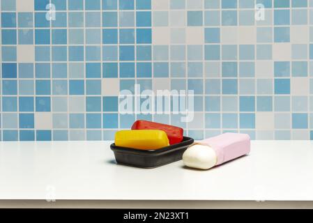 Schale aus schwarzem Porzellan mit Seifenleisten aus Glycerin auf einer weißen Oberfläche Stockfoto