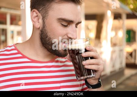 Ein hübscher Mann mit kaltem Kavass draußen. Traditionelles russisches Sommergetränk Stockfoto