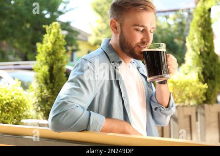 Ein hübscher Mann mit kaltem Kavass draußen. Traditionelles russisches Sommergetränk Stockfoto
