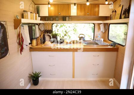 Stilvolle Küche mit verschiedenen Gläsern und Utensilien in einem modernen Wohnwagen. Campingurlaub Stockfoto