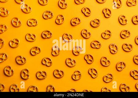 Leckere Brezeln-Cracker auf orangefarbenem Hintergrund, flach liegend Stockfoto