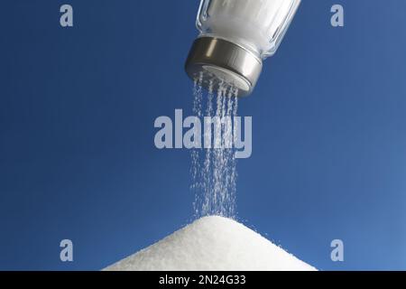 Salz aus dem Schüttler auf blauem Hintergrund, Nahaufnahme Stockfoto