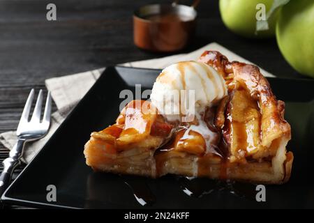 Scheibe von traditionellem Apfelkuchen mit Eis, serviert auf dem Tisch, Nahaufnahme Stockfoto