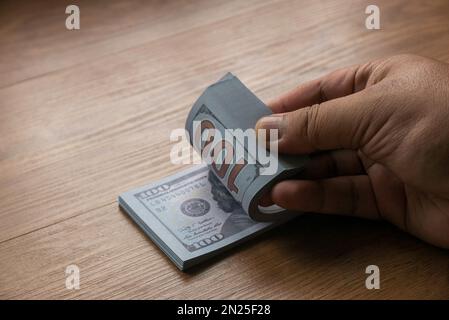 Selektiver Fokus einer Hand berechnet einen Haufen Geld. Stockfoto