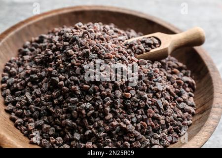 Schwarzes Salz in einer Holzschüssel mit Schaufel, Nahaufnahme Stockfoto