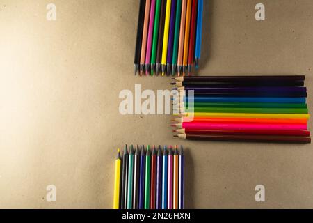 Gestapelte Buntstifte. Isoliert auf braunem Hintergrund. Nahaufnahme. Stockfoto