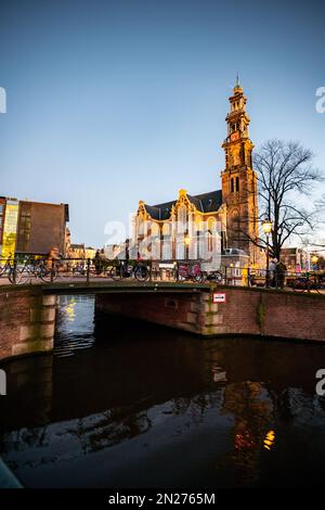 Blick Auf Den Amsterdamer Kanal. Farbenfrohe und historische Gebäude in Amsterdam, Niederlande. Amsterdam in der Abenddämmerung im Februar. Stockfoto