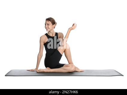 Junge Frau in Sportbekleidung, die Yoga auf weißem Hintergrund praktiziert Stockfoto