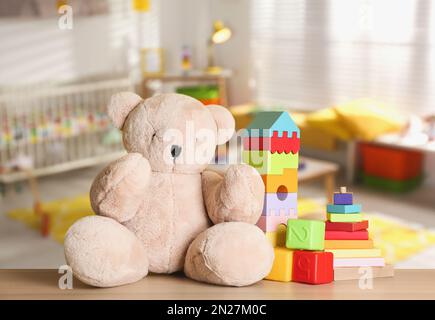 Set mit verschiedenen niedlichen Spielzeugen auf Holztisch im Kinderzimmer Stockfoto