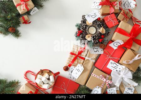 Weihnachts-Adventskalender mit Geschenken und Kakao auf weißem Tisch, flach liegend. Platz für Text Stockfoto