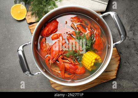 Frische, köstliche Flusskrebse im Topf auf grauem Tisch, flach liegend Stockfoto