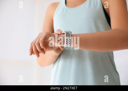 Frau, die drinnen Fitness-Tracker überprüft, Nahaufnahme Stockfoto