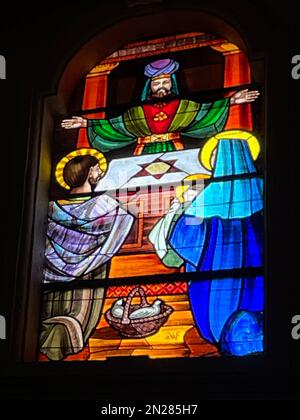 Racale, Italien. Kirche des Heiligen Georges, dem Märtyrer. Buntglas zeigt Maria und Joseph, wie sie das Jesuskind in den Tempel in Jerusalem bringen. Stockfoto