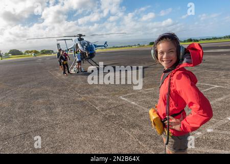 Hubschrauberrundflug Asiatische Touristen auf dem Flughafen zu Fuß zum Tourismusausflug Sommerreise Urlaubsaktivität. Eine Frau, die in die Kamera schaut Stockfoto