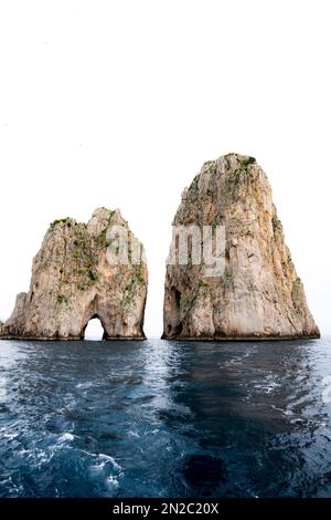 Capri Felsformationen Faraglioni in Süditalien. Augenhöhe mit Blick auf den Ozean des berühmten Faraglioni vor der Küste der Insel Capri. Stockfoto