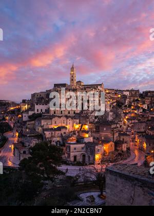 Sonnenuntergang über den antiken Höhlenbewohnungen von Matera in Süditalien. Matera, in der süditalienischen Region Basilikata, UNESCO-Weltkulturerbe. Stockfoto