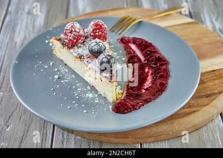 Käsekuchen ohne Teig mit roter Fruchtsauce Stockfoto