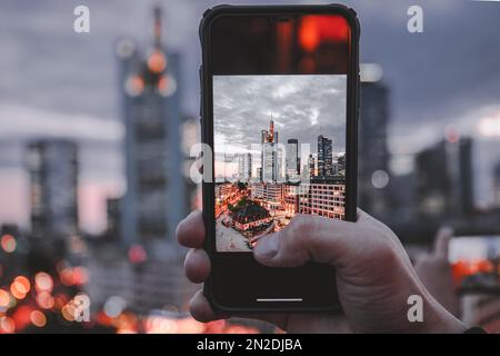 Die Hauptwache, Blick von oben auf einen Platz mit Geschäften und Restaurants, im Hintergrund die Skyline am Abend beleuchtet, handgehalten Stockfoto