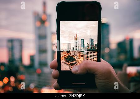 Die Hauptwache, Blick von oben auf einen Platz mit Geschäften und Restaurants, im Hintergrund die Skyline am Abend beleuchtet, handgehalten Stockfoto