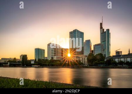 Blick über den Main und die Wolkenkratzer, Frankfurt am Main, lange Belichtung, Sonnenuntergang mit Hintergrundbeleuchtung, Hessen, Deutschland Stockfoto