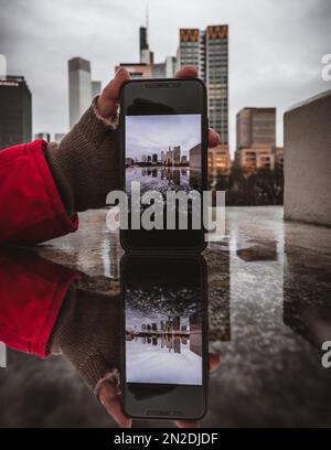 Mobiltelefon fotografiert, Blick auf die Skyline von Frankfurt am Main von der Untermainbrücke, Handheld-Handy mit Foto, Hessen, Deutschland Stockfoto