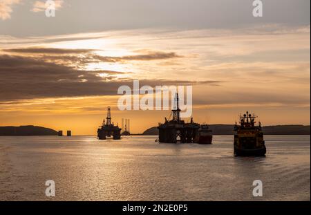 Bohrinseln und ein Versorgungsschiff im Hafengebiet von Invergordon, Großbritannien Stockfoto