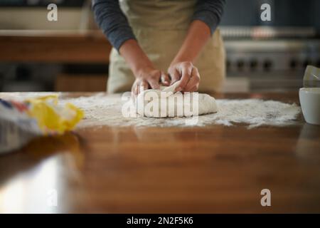 Eine Bäckerin knetet Teig für selbstgebackenes Brot. Stockfoto