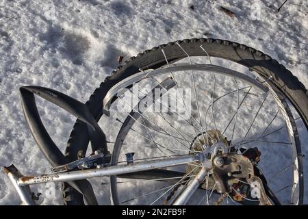 Ein kaputtes Fahrrad lag im Schnee Stockfoto