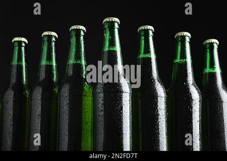 Flaschen Bier auf schwarzem Hintergrund, Nahaufnahme Stockfoto