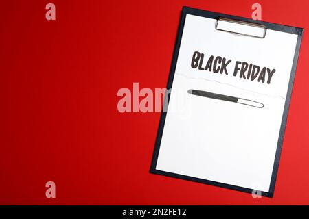 Zwischenablage mit Phrase Black Friday auf rotem Hintergrund, Draufsicht. Platz für Text Stockfoto