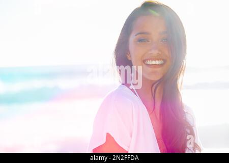 Gefüllt mit der Vitalität des Sommers. Hübsche Frau, die draußen steht und vor der Kamera lächelt. Stockfoto