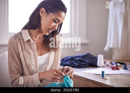 Alles hängt von den Details ab. Ein junger Modedesigner, der an einem neuen Design arbeitet. Stockfoto