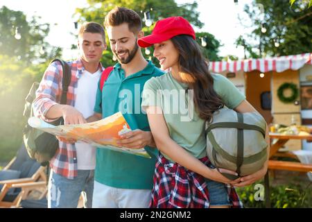 Junge Reisende mit Rucksäcken und Stadtplan planen Ausflüge im Freien Stockfoto