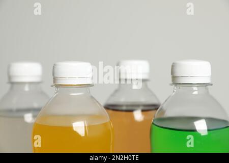 Flaschen mit alkoholfreien Getränken auf grauem Hintergrund, Nahaufnahme Stockfoto