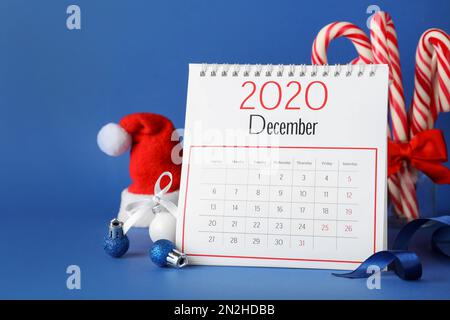 Flip-Kalender und Weihnachtsdekor auf blauem Hintergrund. Feiertagszähler Stockfoto