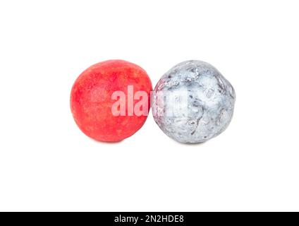 Zwei Bonbons rot und helle Haselnüsse in Schokolade auf weißem Hintergrund Stockfoto