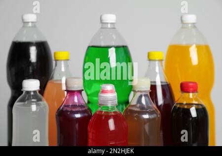 Flaschen mit alkoholfreien Getränken auf grauem Hintergrund, Nahaufnahme Stockfoto