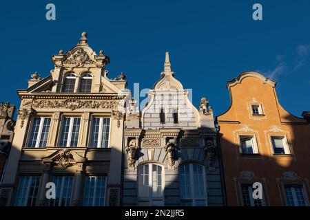 Wunderschöne historische Bürgerhäuser mit Giebeln und dekorierten Fassaden bei Sonnenuntergang in Danzig in Polen, an der Long Street in der Altstadt. Stockfoto