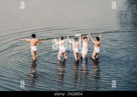 7. FEBRUAR 2023 - Männer nehmen an einer Yakudoshi-Zeremonie während des Kinekosa Festivals im Shichisho-sha-Schrein in Nagoya, Japan, Teil. Das Festival geht auf mehr als 1.000 Jahre zurück. Zehn Yakudoshi-Männer (Pechsträhne) und zwei Jungen paraten vom Schrein mit einer Bambusstange. Sie tragen die Stange in den Fluss Shonai, und die Männer wechseln sich ab und klettern die Stange hoch, bis sie bricht. Ob es ein glückliches oder ein unglückliches Jahr wird, hängt davon ab, in welche Richtung es geht. Kredit: Ben Weller/AFLO/Alamy Live News Stockfoto