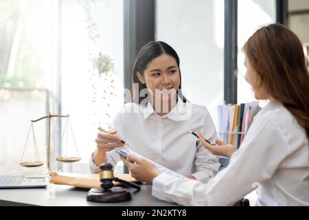 Rechtsanwalt Rechtsbeistand legt dem Mandanten einen unterzeichneten Vertrag mit Hammer und Recht vor. Jurist und Jurist Partnerschafts-Meeting-Konzept Stockfoto
