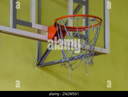 Basketballkorb auf gelbem Hintergrund. Im Fitnessstudio Stockfoto