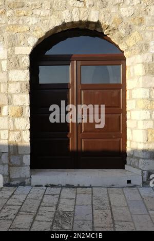 Alte Holztür in der Steinmauer des Klosters Stockfoto