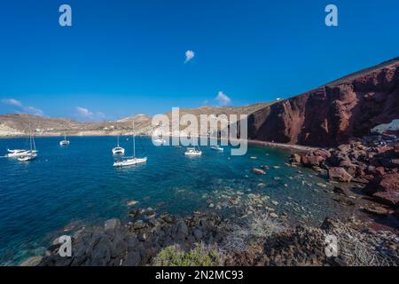 Red Beach, Santorin, Griechenland - August 2022 : Rote Felsenküste und kristallklares Wasser an einem beliebten und wunderschönen griechischen Strand Stockfoto