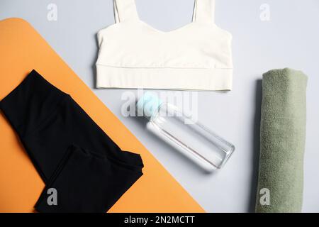 Flache Laienzusammensetzung mit Yoga-Ausrüstung auf grauem Hintergrund Stockfoto