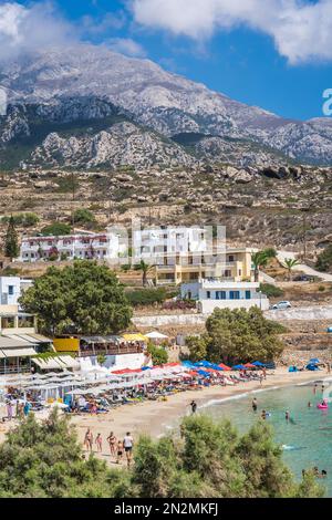 Lefkos Beach, Karpathos, Griechenland - August 2022 : Hotels und Restaurants oberhalb des weißen Sandstrands und kristallklarem Wasser auf einem beliebten und wunderschönen Hotel Stockfoto