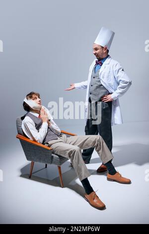 Ich flehe dich an, Schmerzen zu heilen. Junger Mann mit Zahnproblemen beim Zahnarzt, Doktor. Medizin. Modelle vor grauem Studiohintergrund Stockfoto