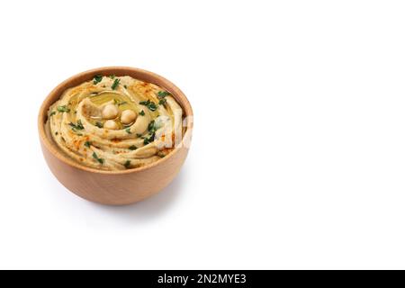 Kichererbsen-Hummus in einer Holzschüssel, garniert mit Petersilie, Paprika und Olivenöl, isoliert auf weißem Hintergrund Stockfoto