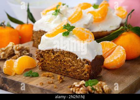 Karottenkuchen mit Sahne-Zuckerguss und Mandarinenstücken. Stockfoto