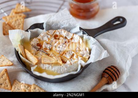 camembert weicher französischer Käse im Ofen mit Honig und Thymian, Seitenansicht Stockfoto